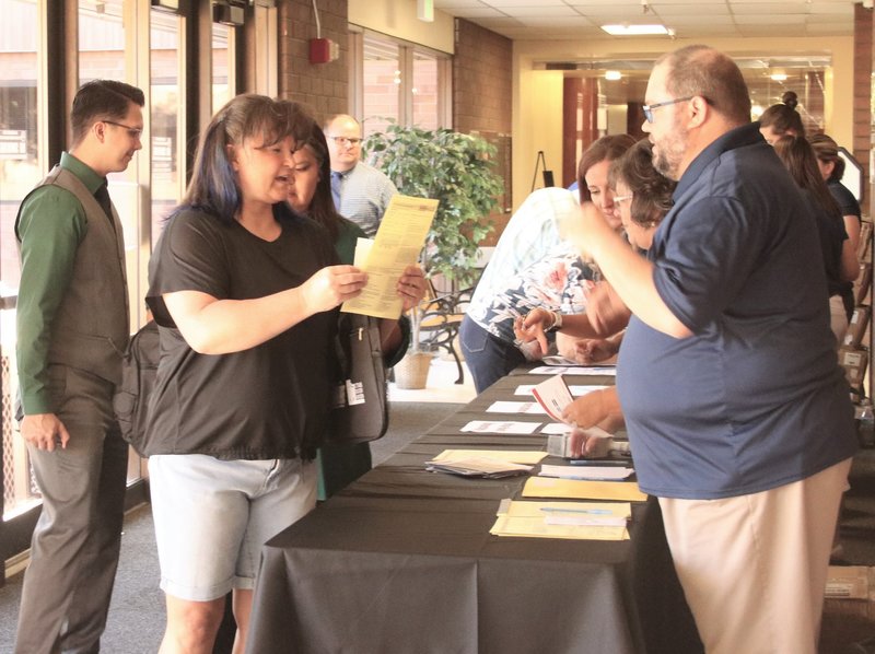 Teachers who came to the institute pick up materials before it began.